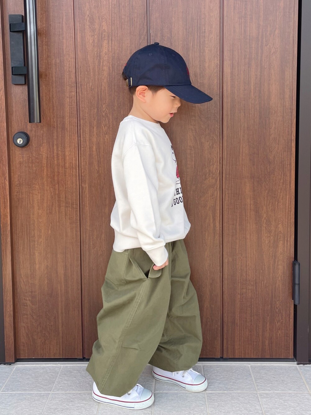 ホワイト系のトップス、グリーン系のその他パンツ、ホワイト系のスニーカーを着用したキッズの秋コーディネートの2枚目の写真