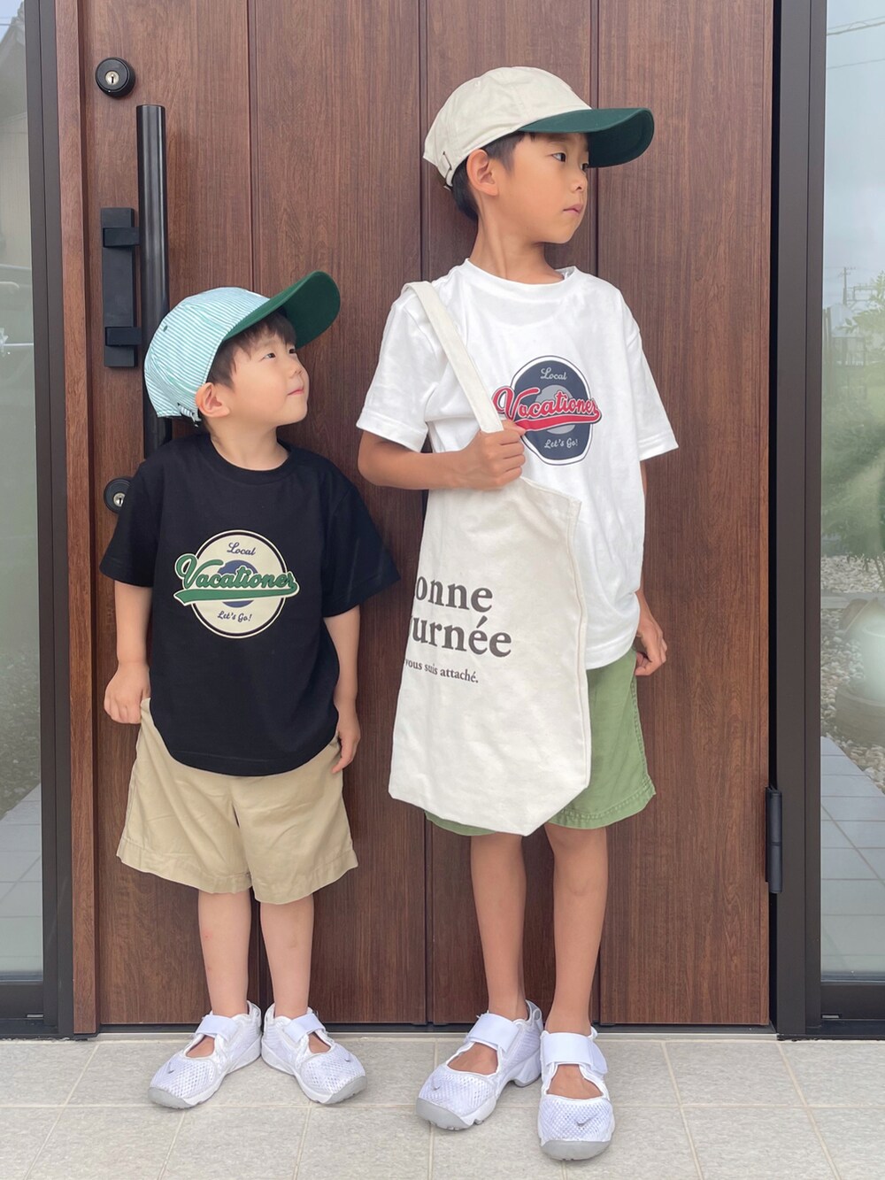 ブラック系のトップス、ベージュ系のパンツ、ホワイト系のスニーカーを着用したキッズの夏コーディネートの3枚目の写真