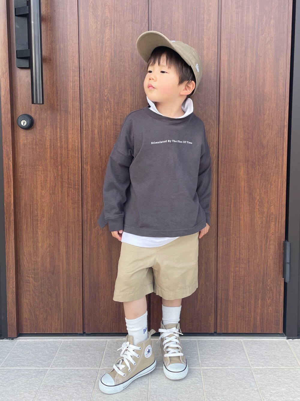グレー系のTシャツ/カットソー、ホワイト系のトップス、ベージュ系のパンツを着用したキッズの春コーディネートの2枚目の写真