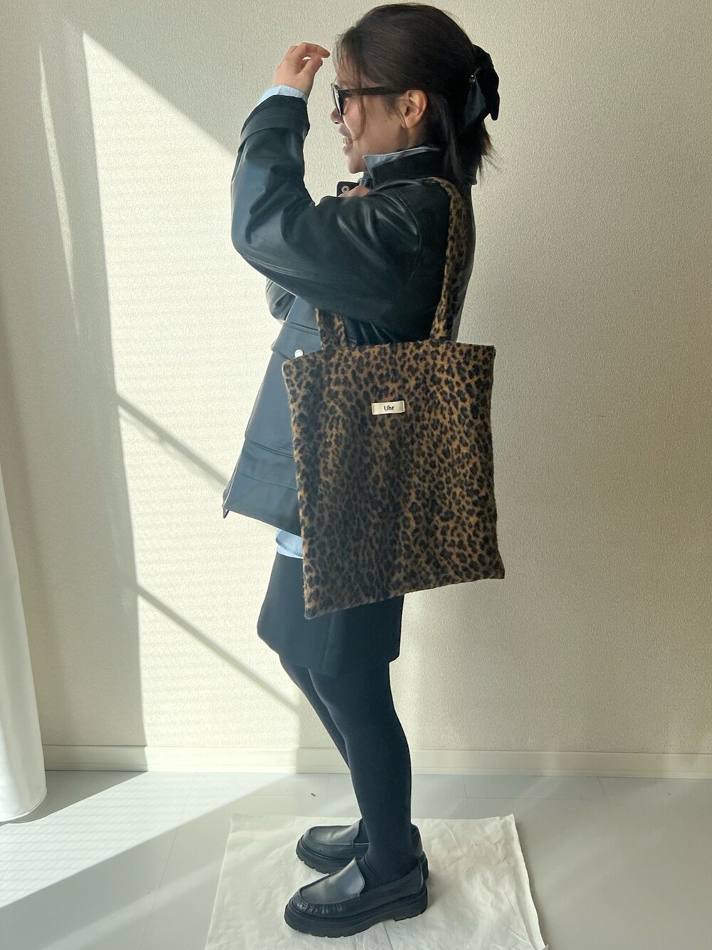 ブラウン系のトートバッグ、ブラック系のジャケット/アウターを着用したレディースの冬コーディネートの3枚目の写真