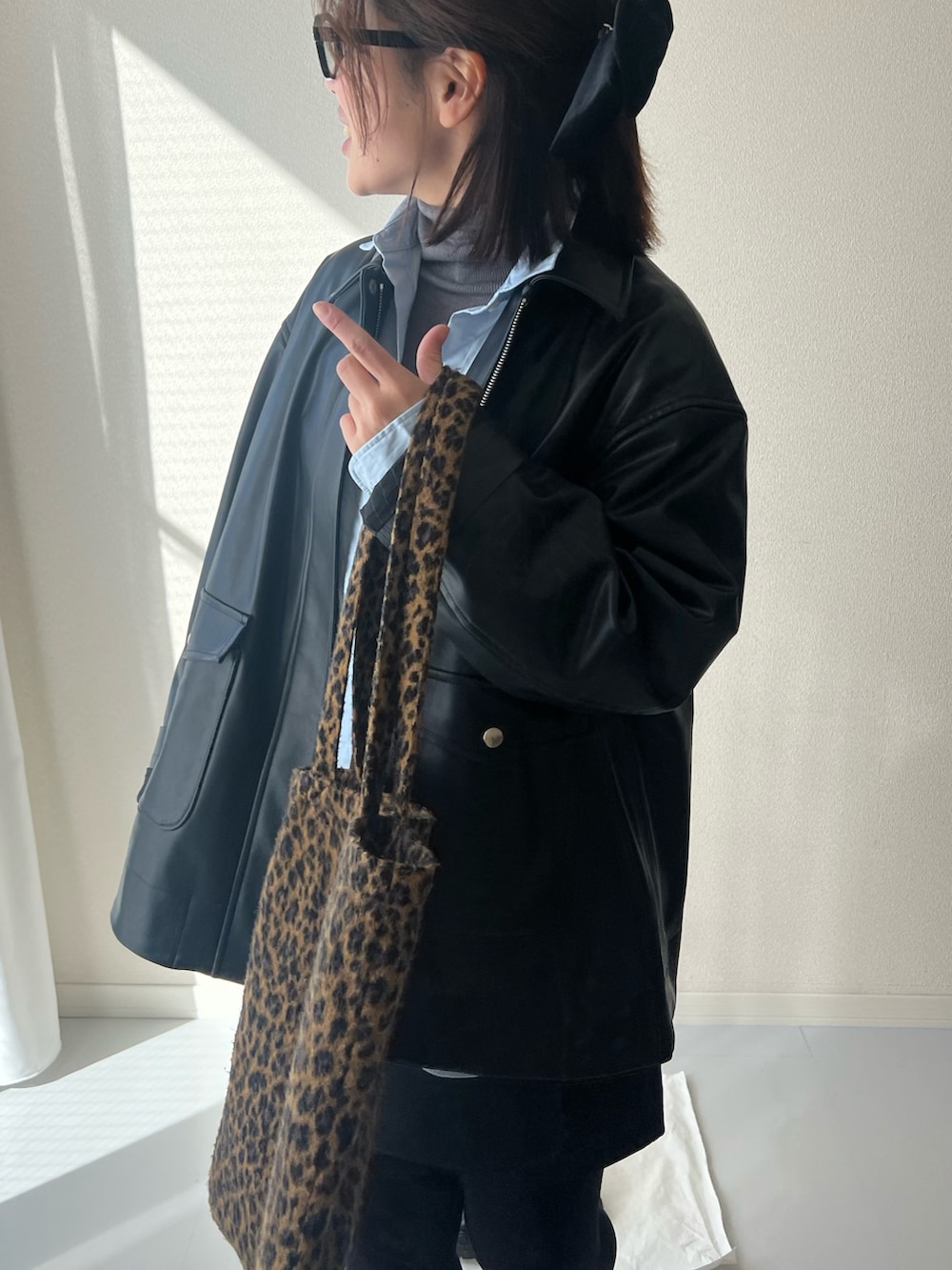 ブラウン系のトートバッグ、ブラック系のジャケット/アウターを着用したレディースの冬コーディネートの5枚目の写真