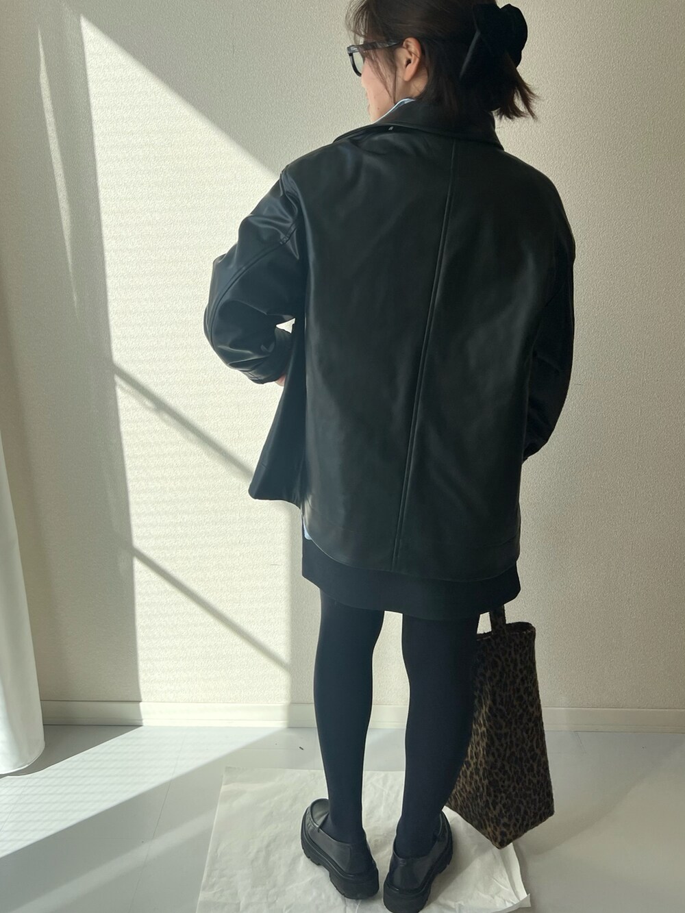 ブラウン系のトートバッグ、ブラック系のジャケット/アウターを着用したレディースの冬コーディネートの4枚目の写真