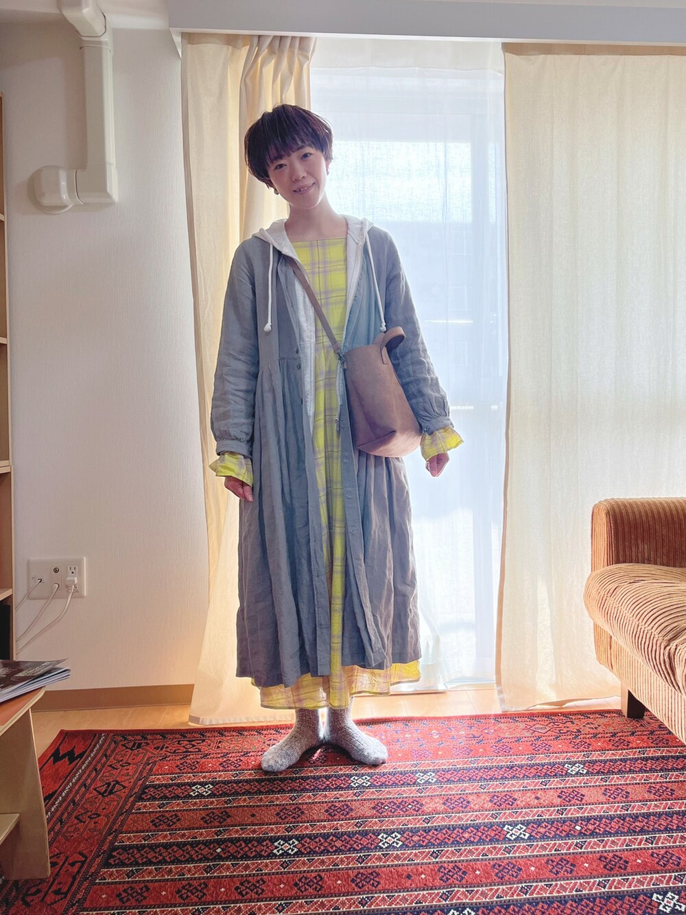 グレー系のワンピース、ホワイト系のパーカー、イエロー系のワンピースを着用したレディースの春コーディネートの2枚目の写真