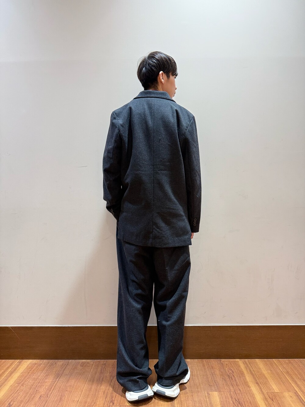 ブラック系のその他アウター、レッド系のニット/セーター、ブラック系のその他パンツを着用したメンズの冬コーディネートの2枚目の写真