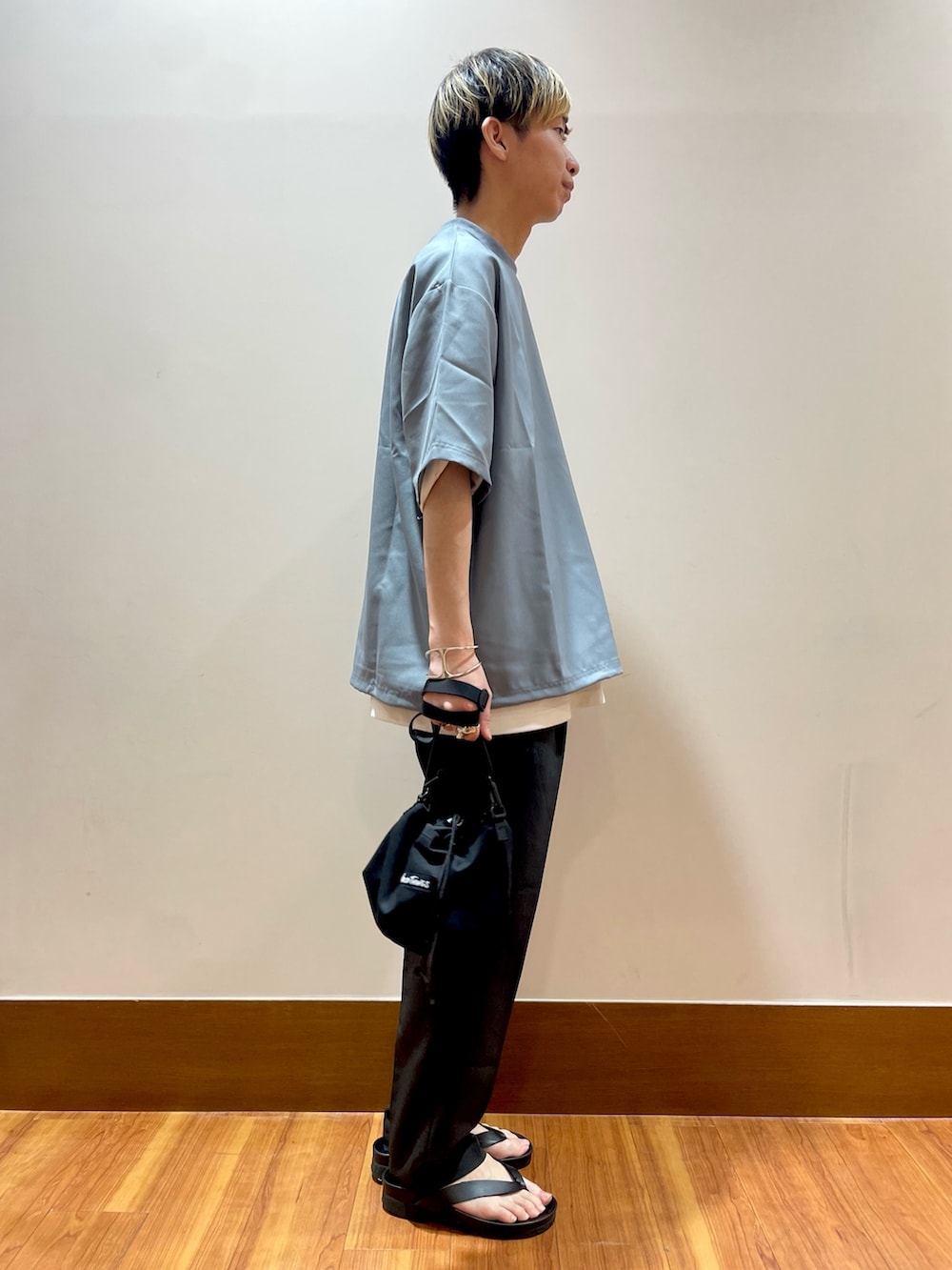 グレー系のTシャツ/カットソー、ブラック系のショルダーバッグ、グレー系のスラックスを着用したメンズの夏コーディネートの4枚目の写真