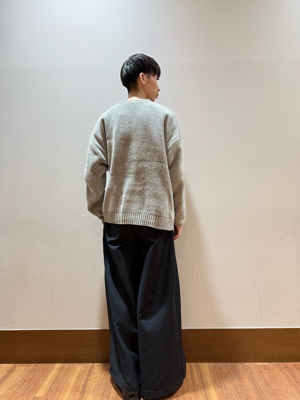 ベージュ系のニット/セーター、ブラック系のスニーカーを着用したメンズの秋コーディネートの2枚目の写真