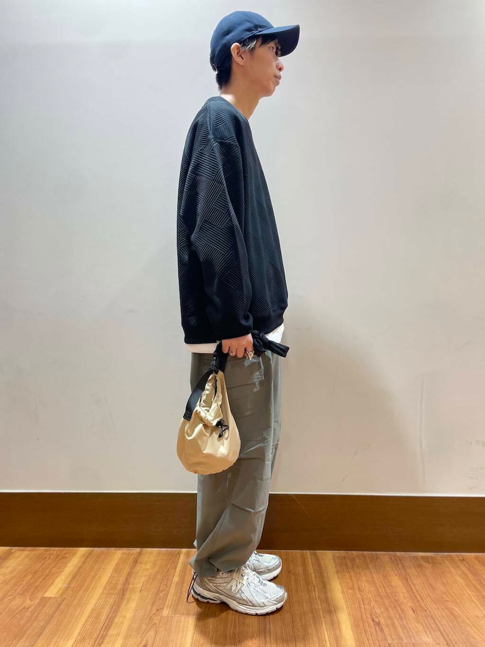 ベージュ系のショルダーバッグ、ホワイト系のTシャツ/カットソー、グレー系のカーゴパンツを着用したメンズの夏コーディネートの4枚目の写真