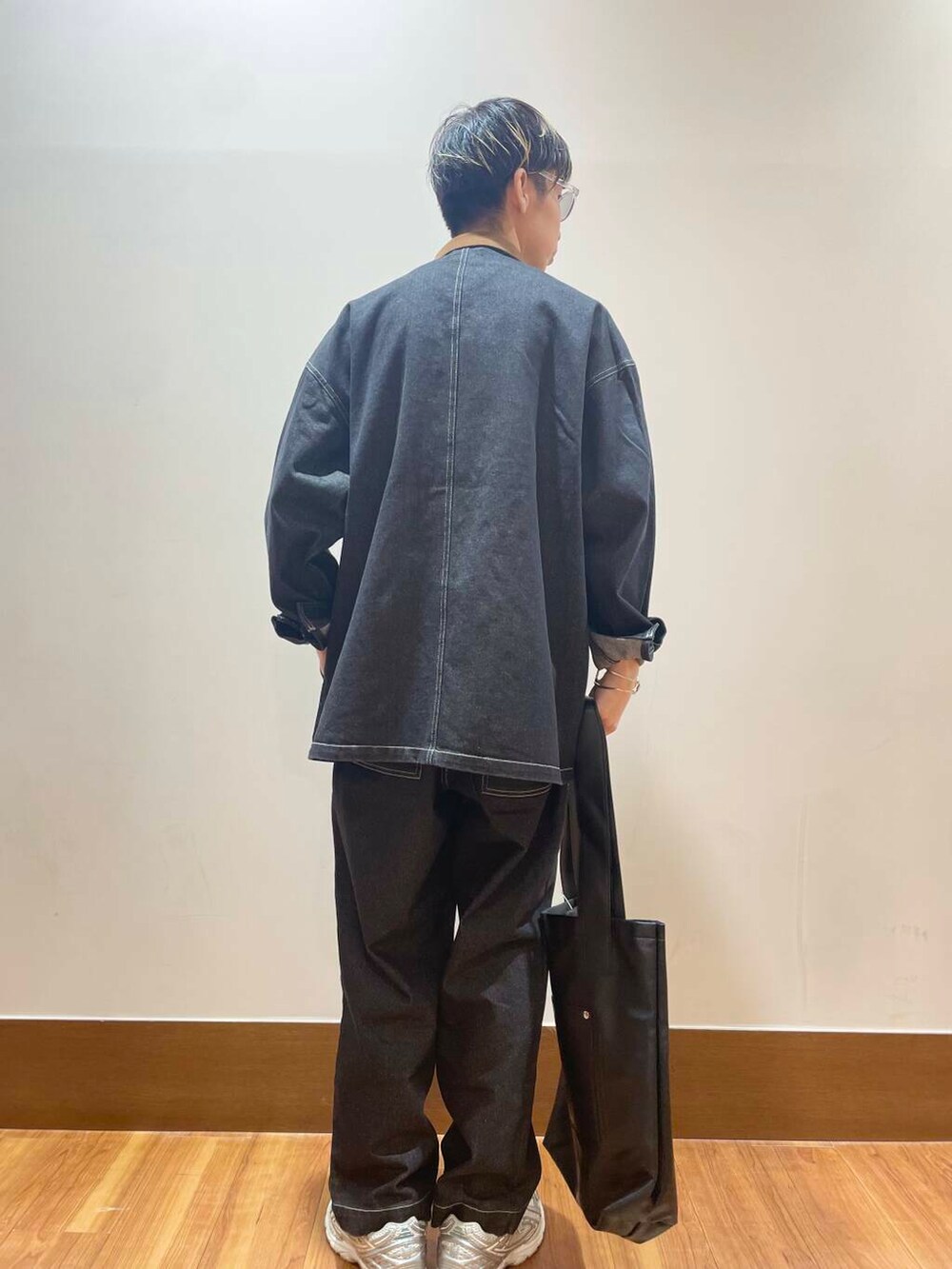 ブラック系のデニムパンツ、ブラック系のカバーオール、ホワイト系のTシャツ/カットソーを着用したメンズの秋コーディネートの3枚目の写真