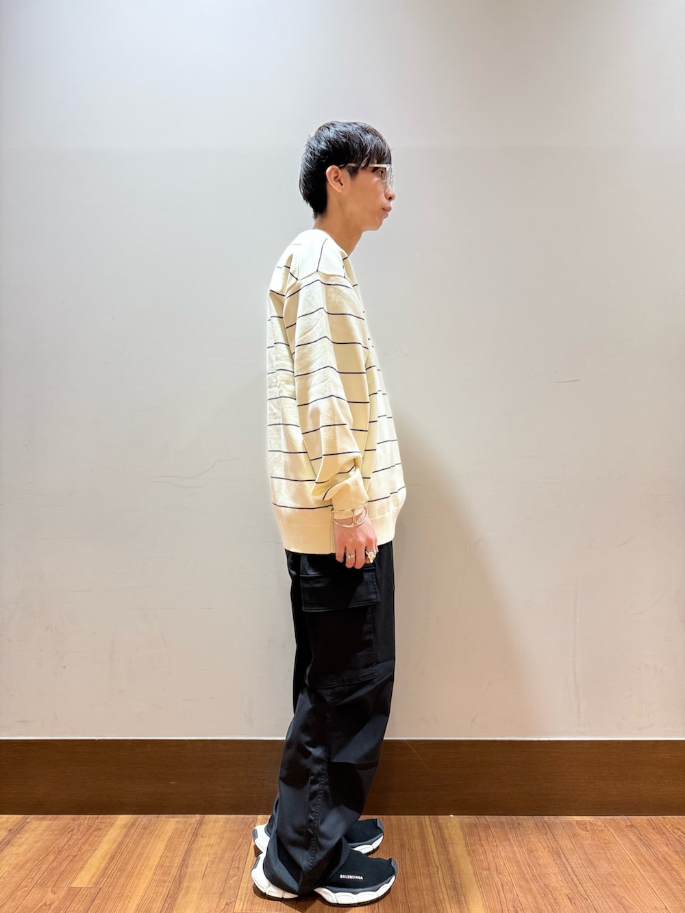 ホワイト系のニット/セーター、ブラック系のその他パンツを着用したメンズの秋コーディネートの4枚目の写真