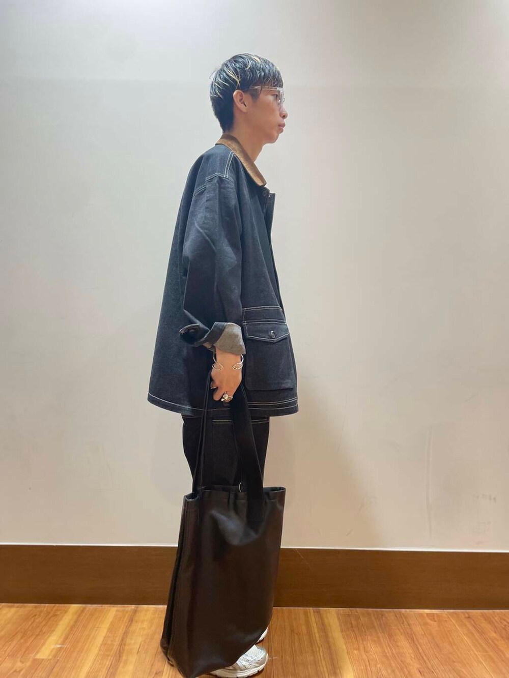 ブラック系のデニムパンツ、ブラック系のカバーオール、ホワイト系のTシャツ/カットソーを着用したメンズの秋コーディネートの2枚目の写真