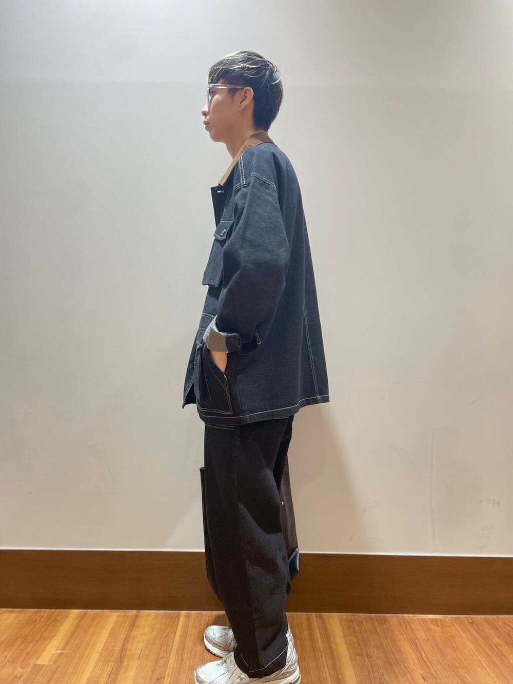 ブラック系のデニムパンツ、ブラック系のカバーオール、ホワイト系のTシャツ/カットソーを着用したメンズの秋コーディネートの4枚目の写真