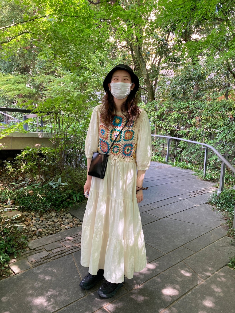 ベージュ系のワンピース、ブラック系のショルダーバッグ、ブラック系のスニーカーを着用したレディースの秋コーディネートの2枚目の写真