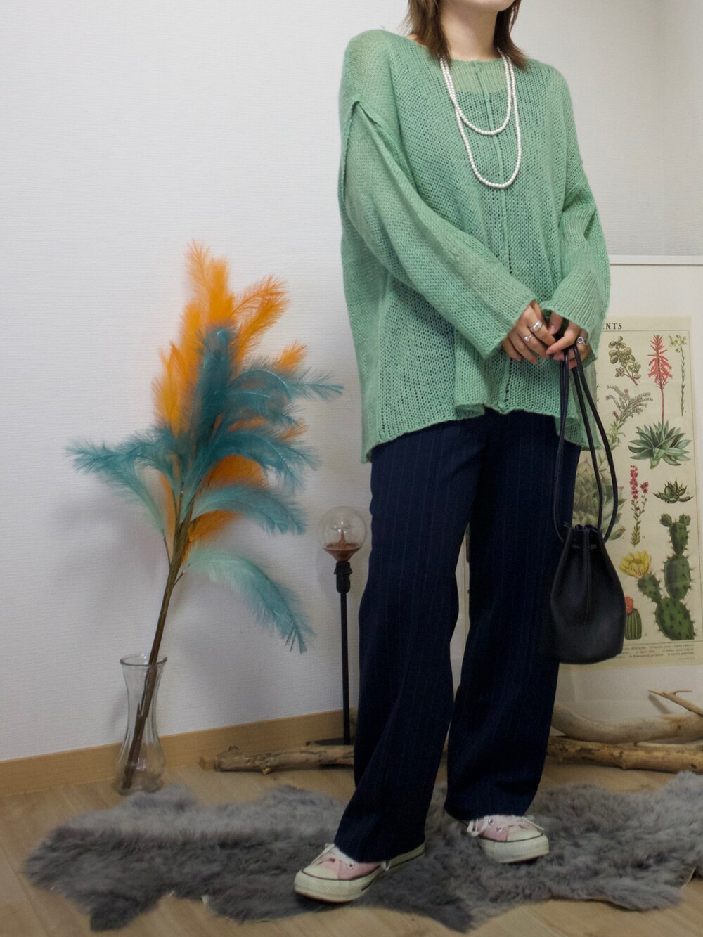 ブルー系のパンツ、ピンク系のスニーカー、ホワイト系のネックレスを着用したレディースの春コーディネートの2枚目の写真