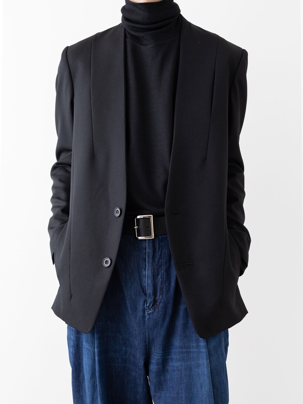 ブルー系のデニムパンツ、ブラック系のノーカラージャケット、ブラック系のニット/セーターを着用したメンズの秋コーディネートの3枚目の写真