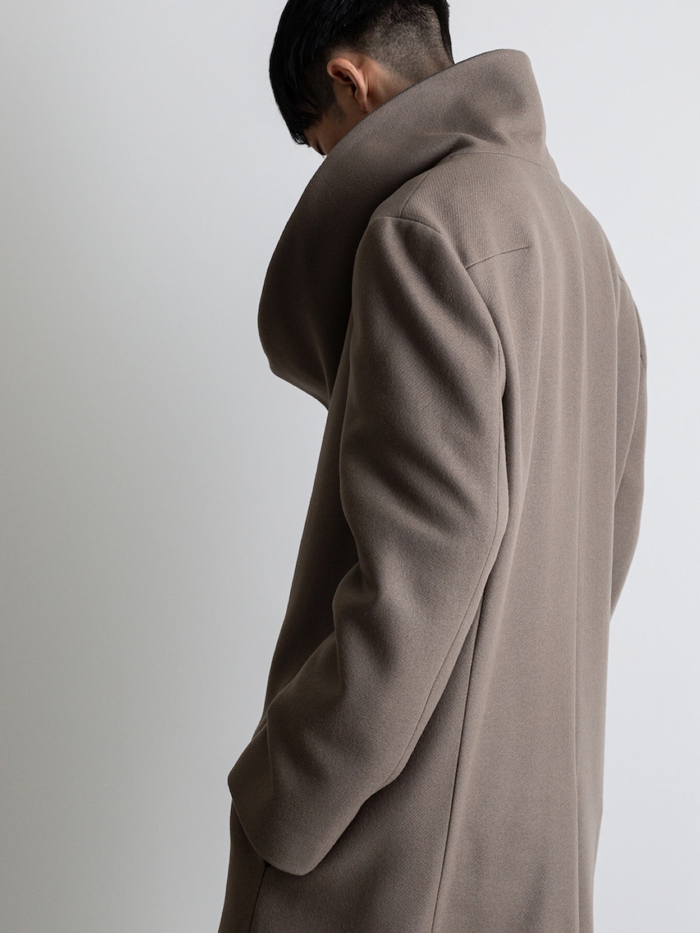 グレー系のその他パンツ、ベージュ系のチェスターコートを着用したメンズの冬コーディネートの4枚目の写真