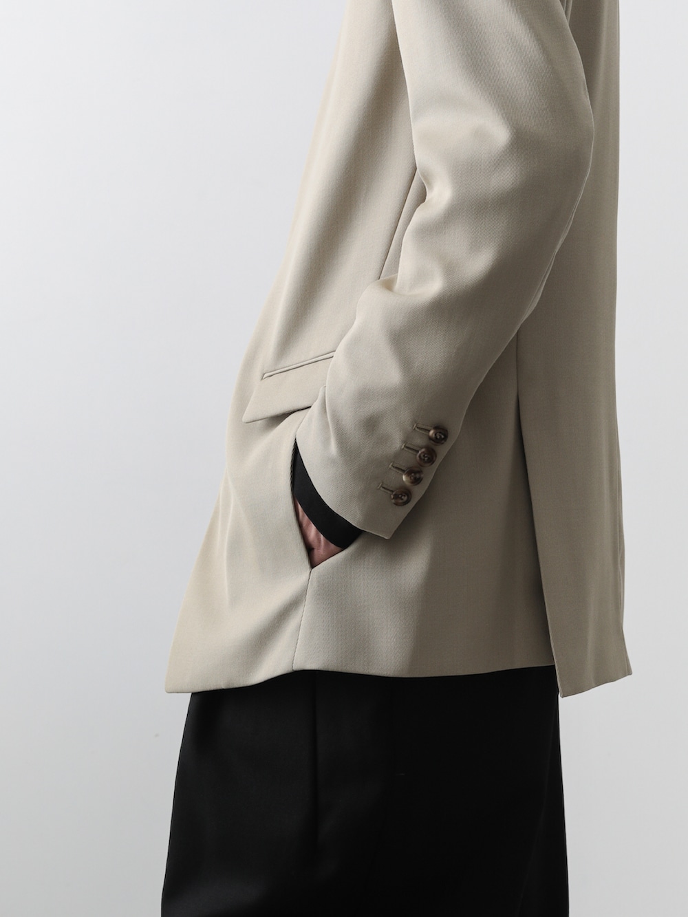 ベージュ系のテーラードジャケット、ブラック系のその他パンツを着用したメンズの秋コーディネートの4枚目の写真