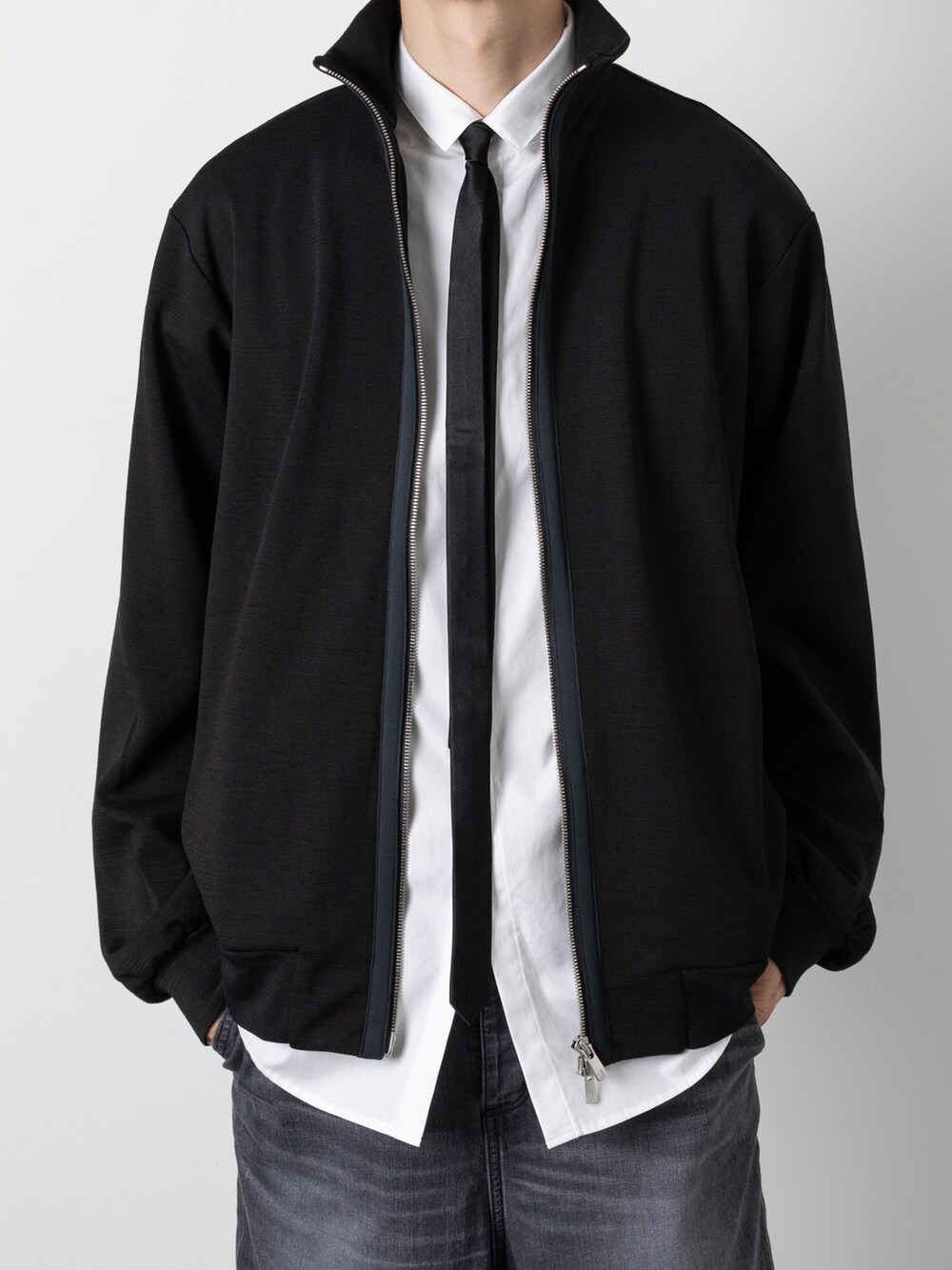 ブラック系のデニムパンツ、ブラック系のネクタイ、ブラック系のニット/セーターを着用したメンズの秋コーディネートの2枚目の写真