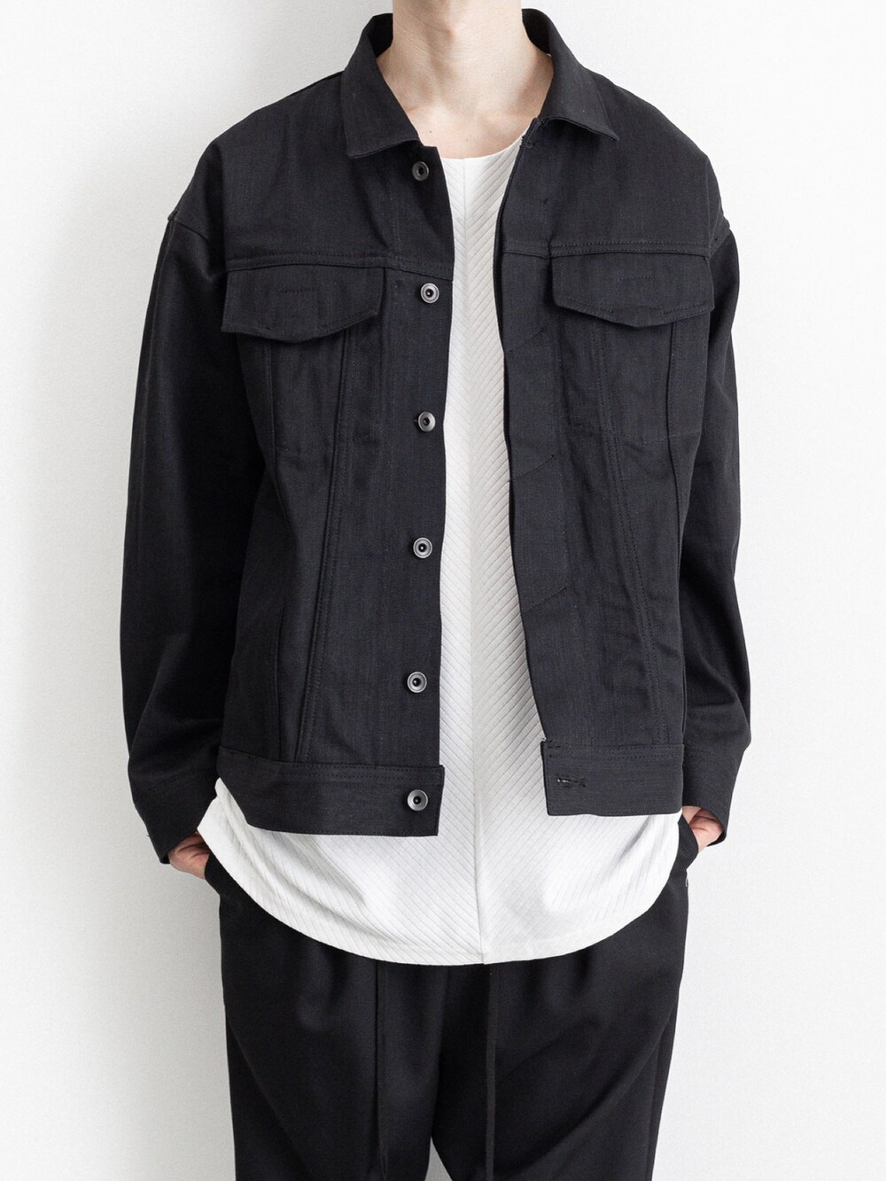 ブラック系のブルゾン、ブラック系のその他パンツ、ホワイト系のTシャツ/カットソーを着用したメンズの春コーディネートの5枚目の写真