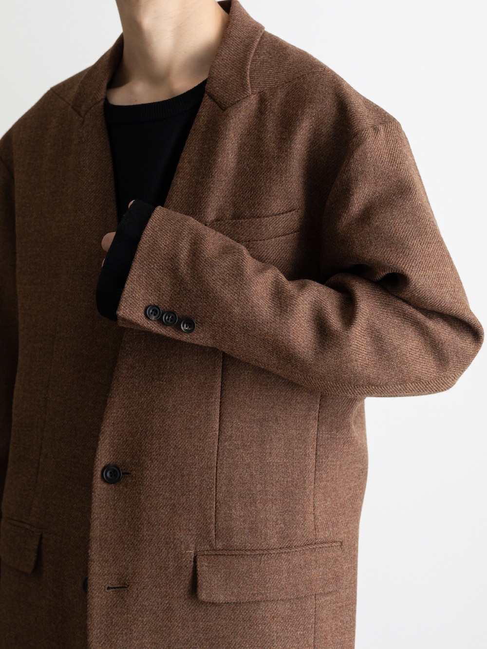 ブラック系のダウンベスト、ブラウン系のノーカラージャケット、ブラック系のその他パンツを着用したメンズの冬コーディネートの5枚目の写真