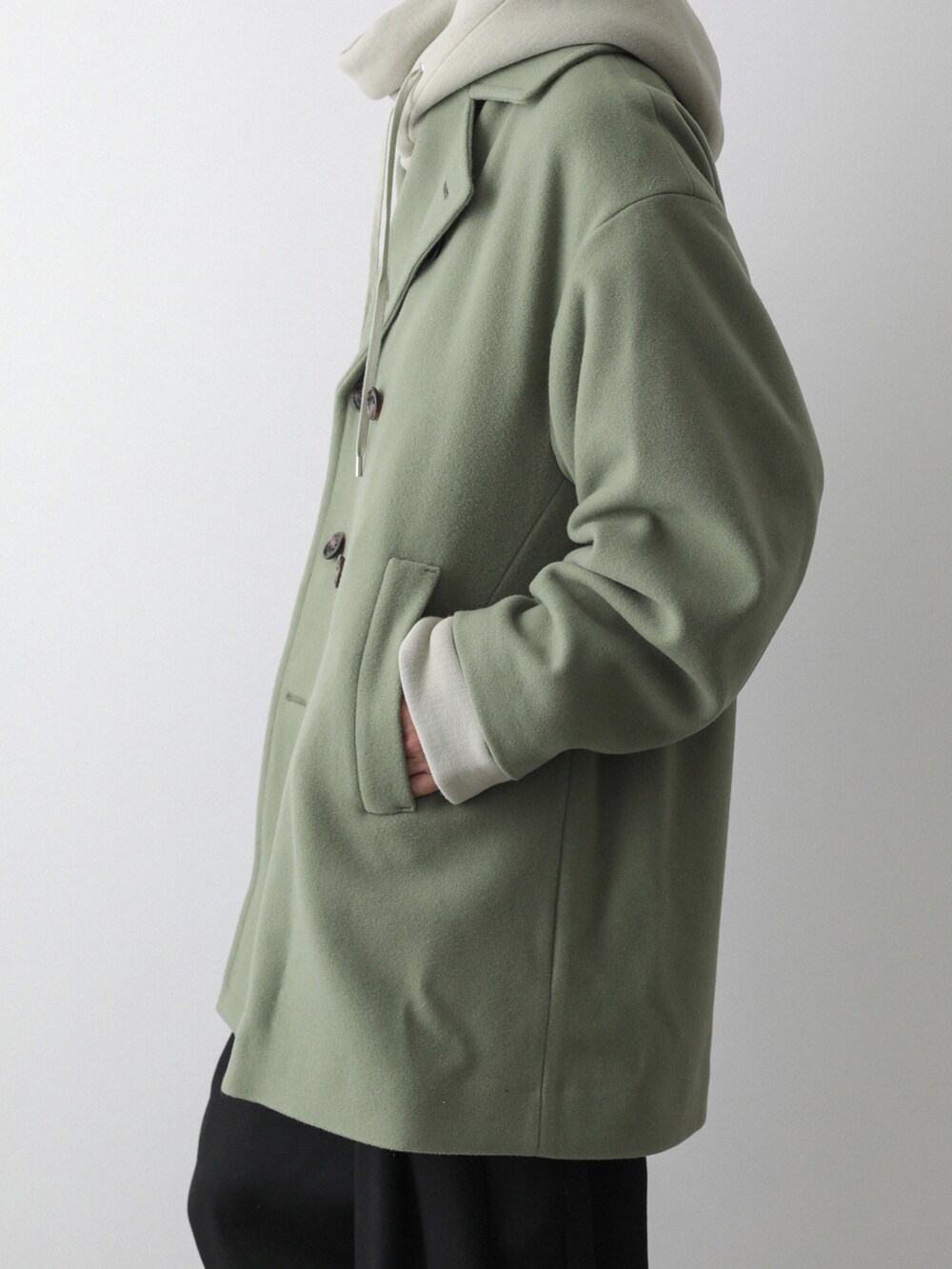 グリーン系のピーコート、グリーン系のパーカー、ブラック系のその他パンツを着用したメンズの秋コーディネートの4枚目の写真