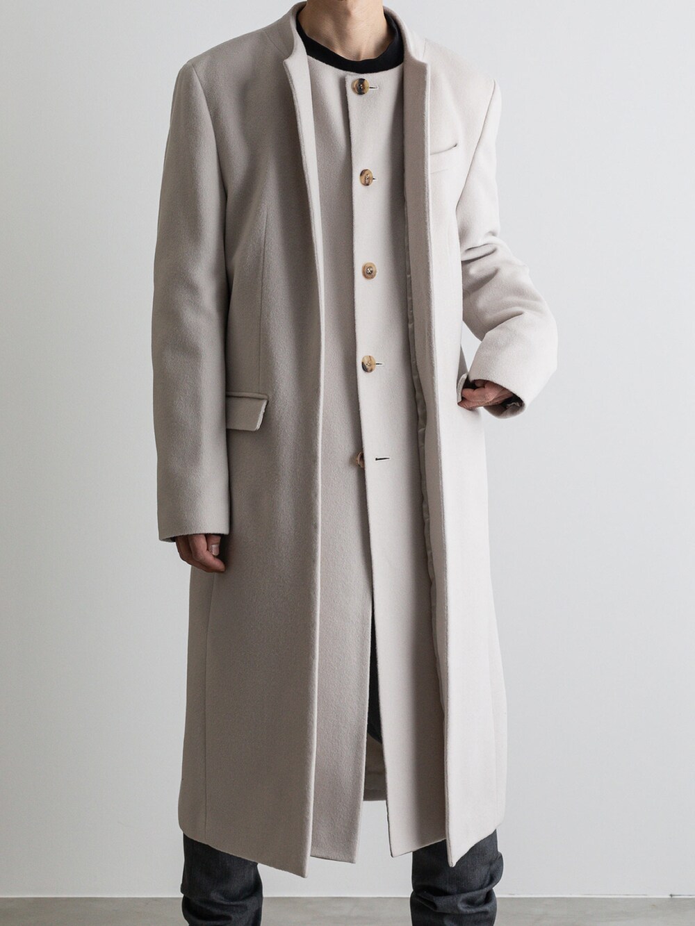 グレー系のその他パンツ、ホワイト系のノーカラーコートを着用したメンズの冬コーディネートの4枚目の写真