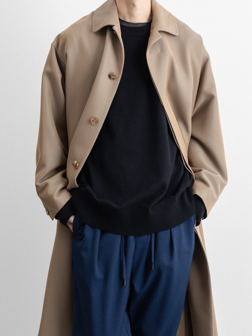 ベージュ系のステンカラーコート、ブルー系のその他パンツを着用したメンズの冬コーディネートの2枚目の写真