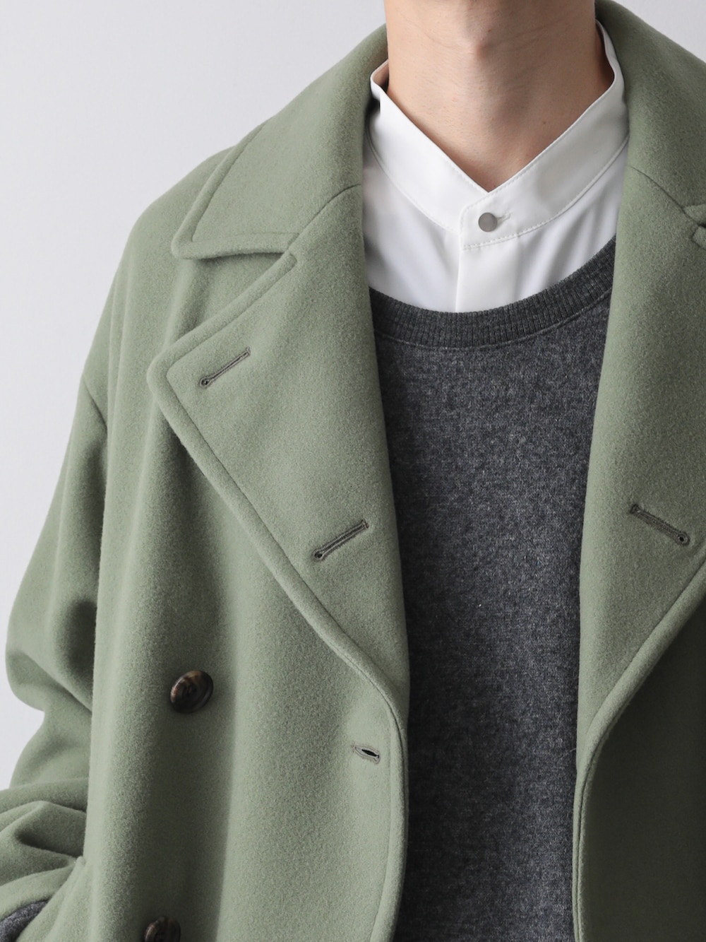 グリーン系のピーコート、グレー系のTシャツ/カットソー、ホワイト系のシャツ/ブラウスを着用したメンズの秋コーディネートの2枚目の写真