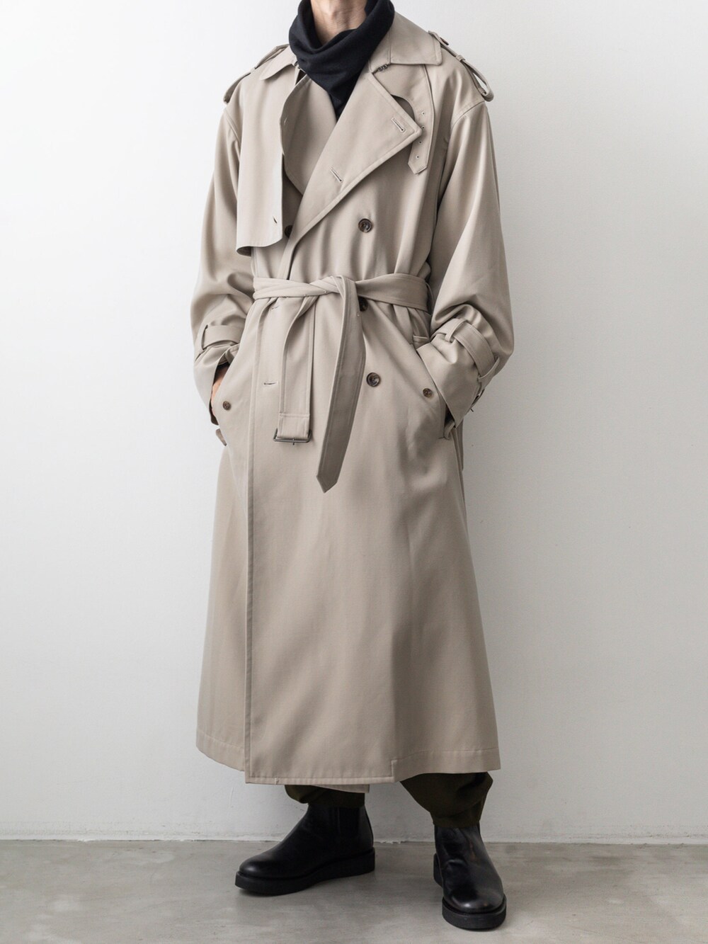 ベージュ系のトレンチコート、グリーン系のその他パンツ、ブラック系のTシャツ/カットソーを着用したメンズの秋コーディネートの4枚目の写真