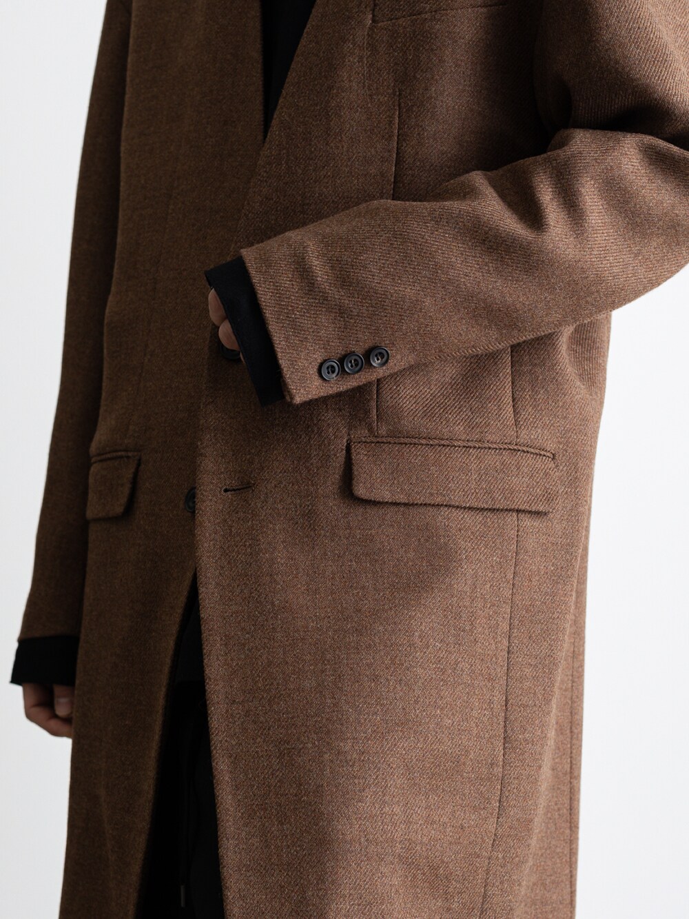 ブラウン系のノーカラージャケット、ブラック系のその他パンツ、ブラック系のTシャツ/カットソーを着用したメンズの冬コーディネートの4枚目の写真