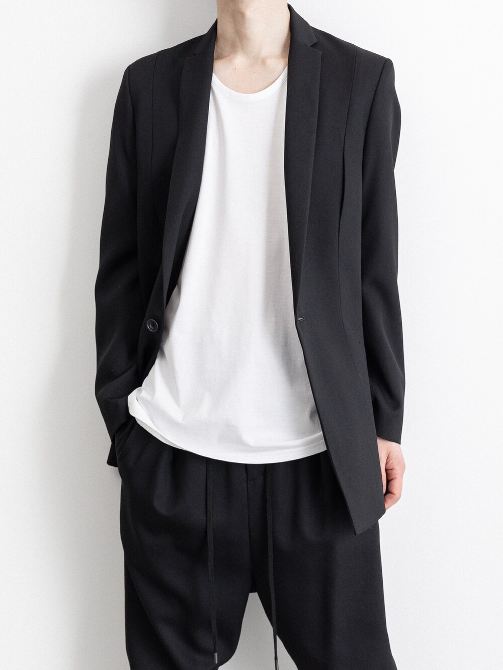 ブラック系のその他パンツ、ホワイト系のTシャツ/カットソー、ブラック系のテーラードジャケットを着用したメンズの春コーディネートの2枚目の写真