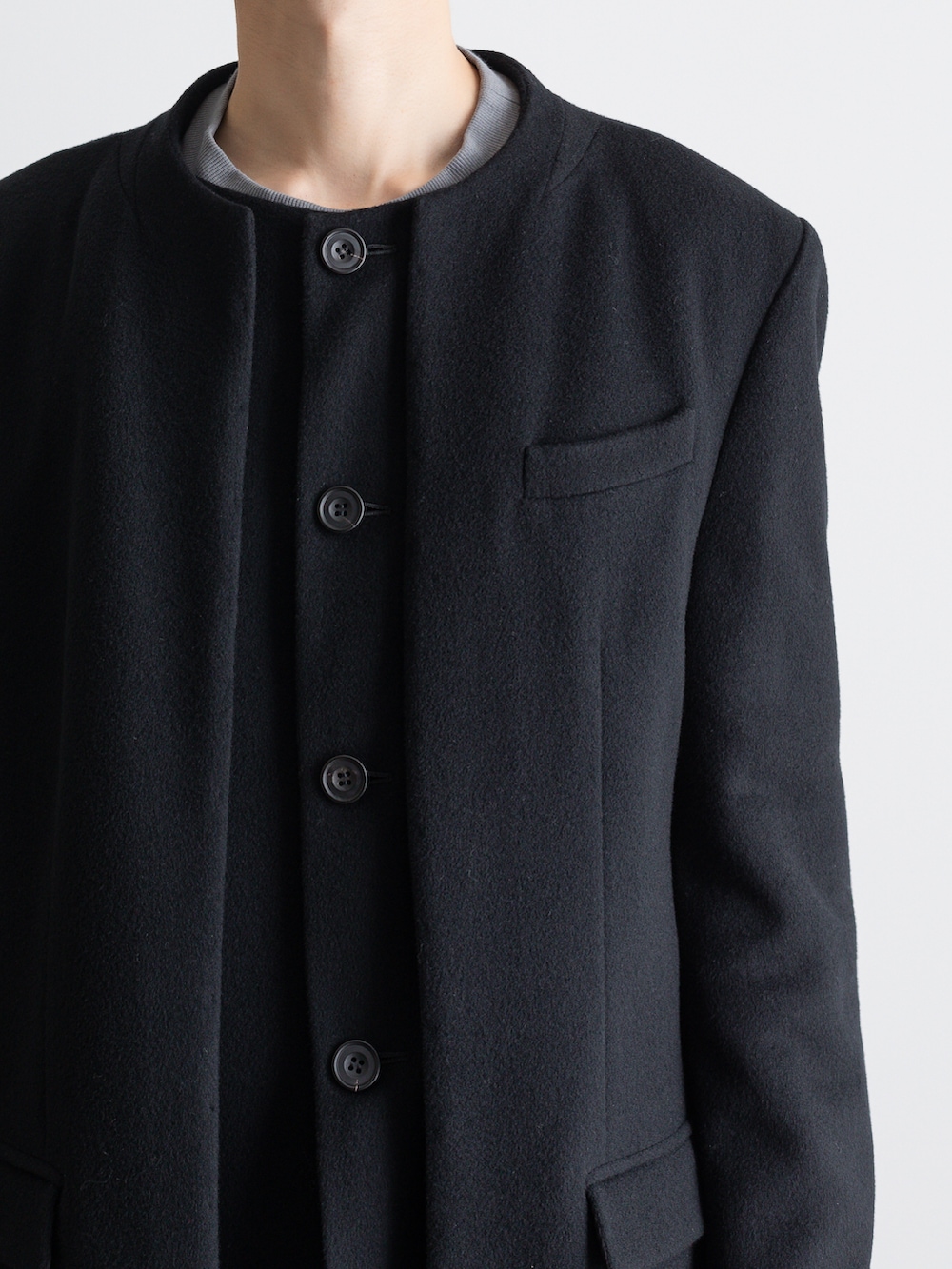 ブラック系のその他パンツ、ブラック系のノーカラーコートを着用したメンズの冬コーディネートの2枚目の写真