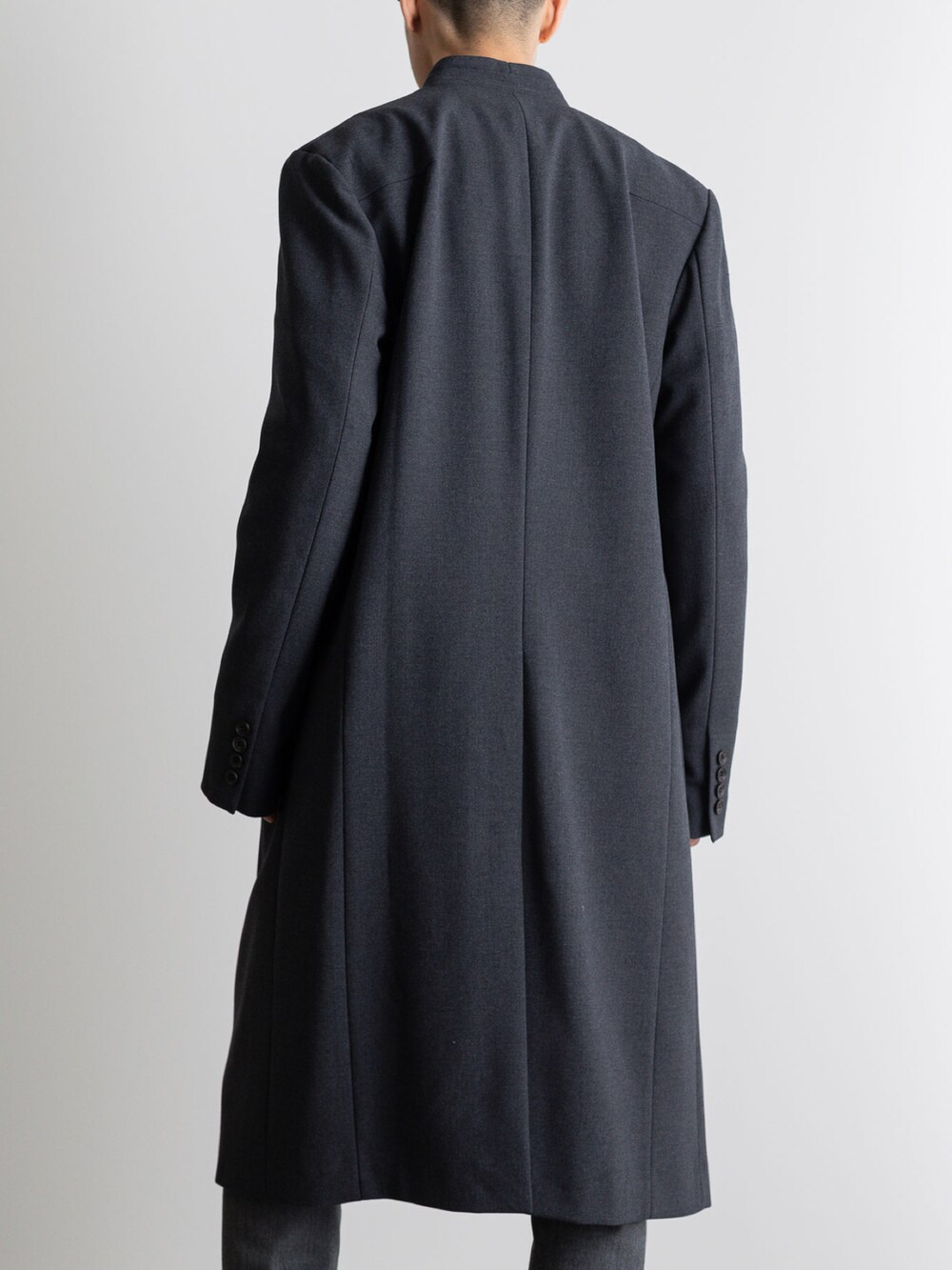 グレー系のその他パンツ、グレー系のノーカラーコートを着用したメンズの冬コーディネートの5枚目の写真