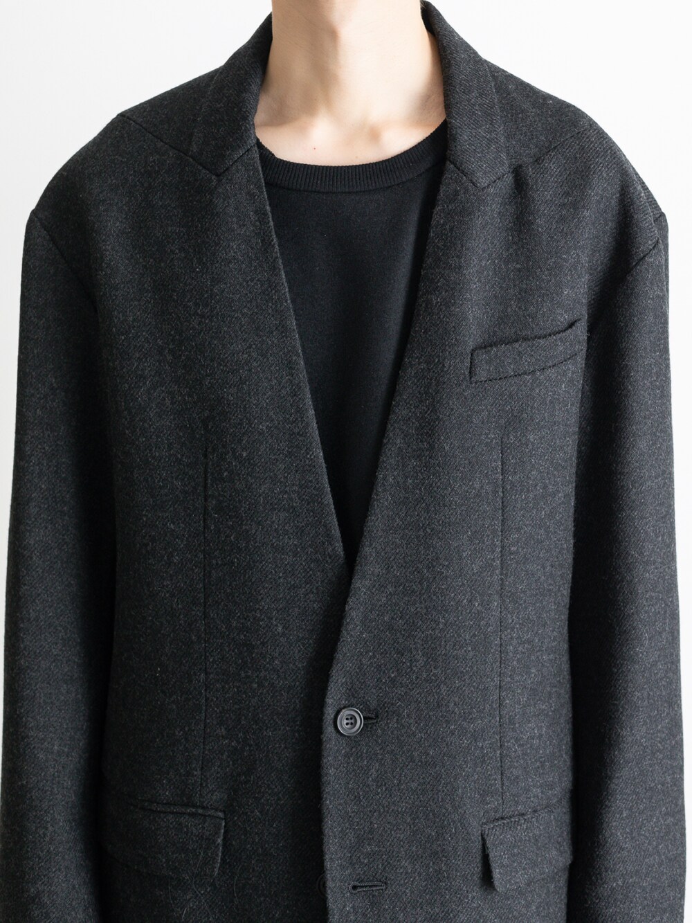 グレー系のノーカラージャケット、ブラック系のその他パンツ、ブラック系のTシャツ/カットソーを着用したメンズの冬コーディネートの2枚目の写真