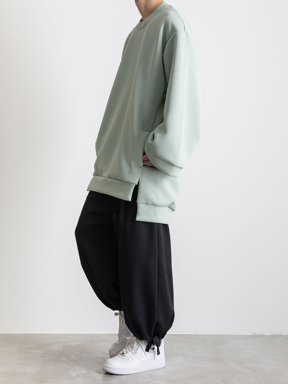 グリーン系のTシャツ/カットソー、ブラック系のその他パンツを着用したメンズの冬コーディネートの5枚目の写真