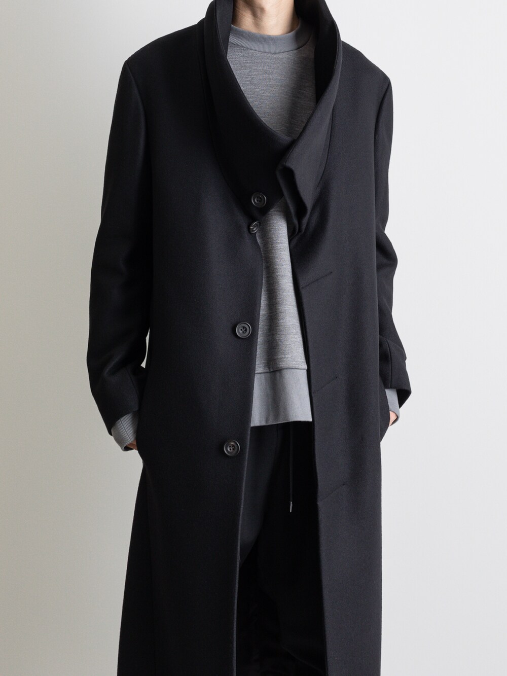 ブラック系のその他パンツ、ブラック系のチェスターコートを着用したメンズの冬コーディネートの2枚目の写真