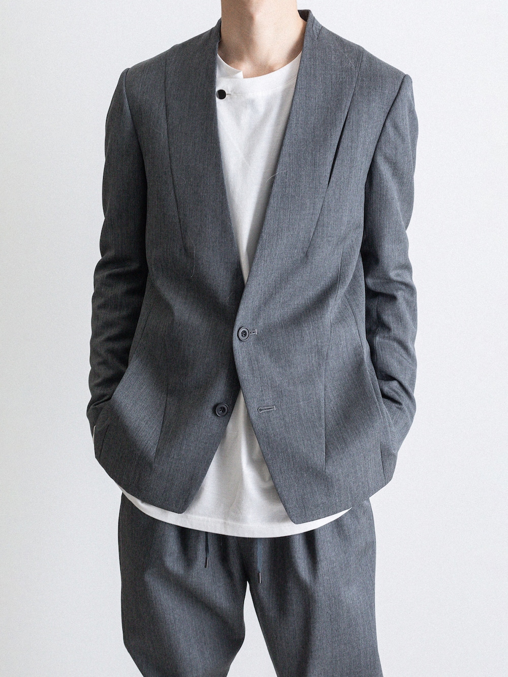 グレー系のその他パンツ、ホワイト系のTシャツ/カットソー、グレー系のノーカラージャケットを着用したメンズの冬コーディネートの3枚目の写真