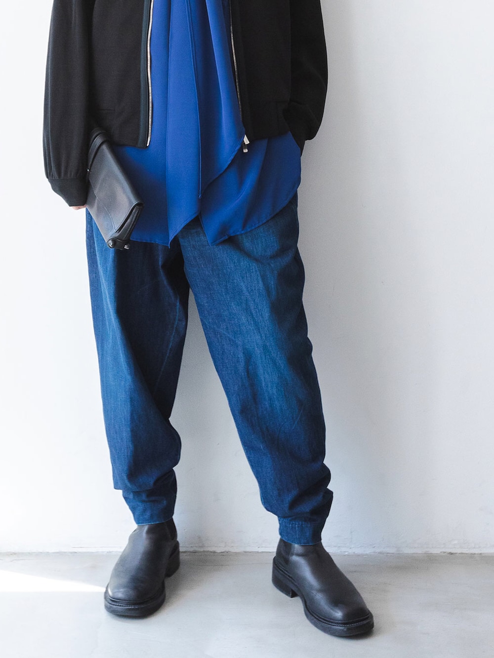 ブルー系のシャツ/ブラウス、ブラック系のニット/セーター、ブルー系のデニムパンツを着用したメンズの秋コーディネートの5枚目の写真