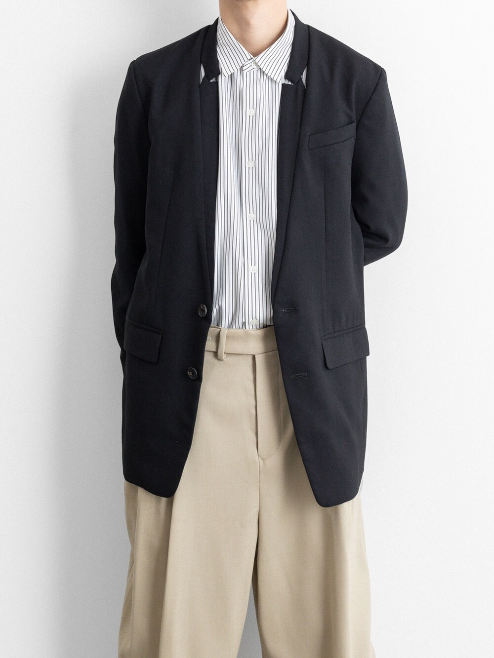 ブラック系のテーラードジャケット、ベージュ系のその他パンツを着用したメンズの冬コーディネートの2枚目の写真