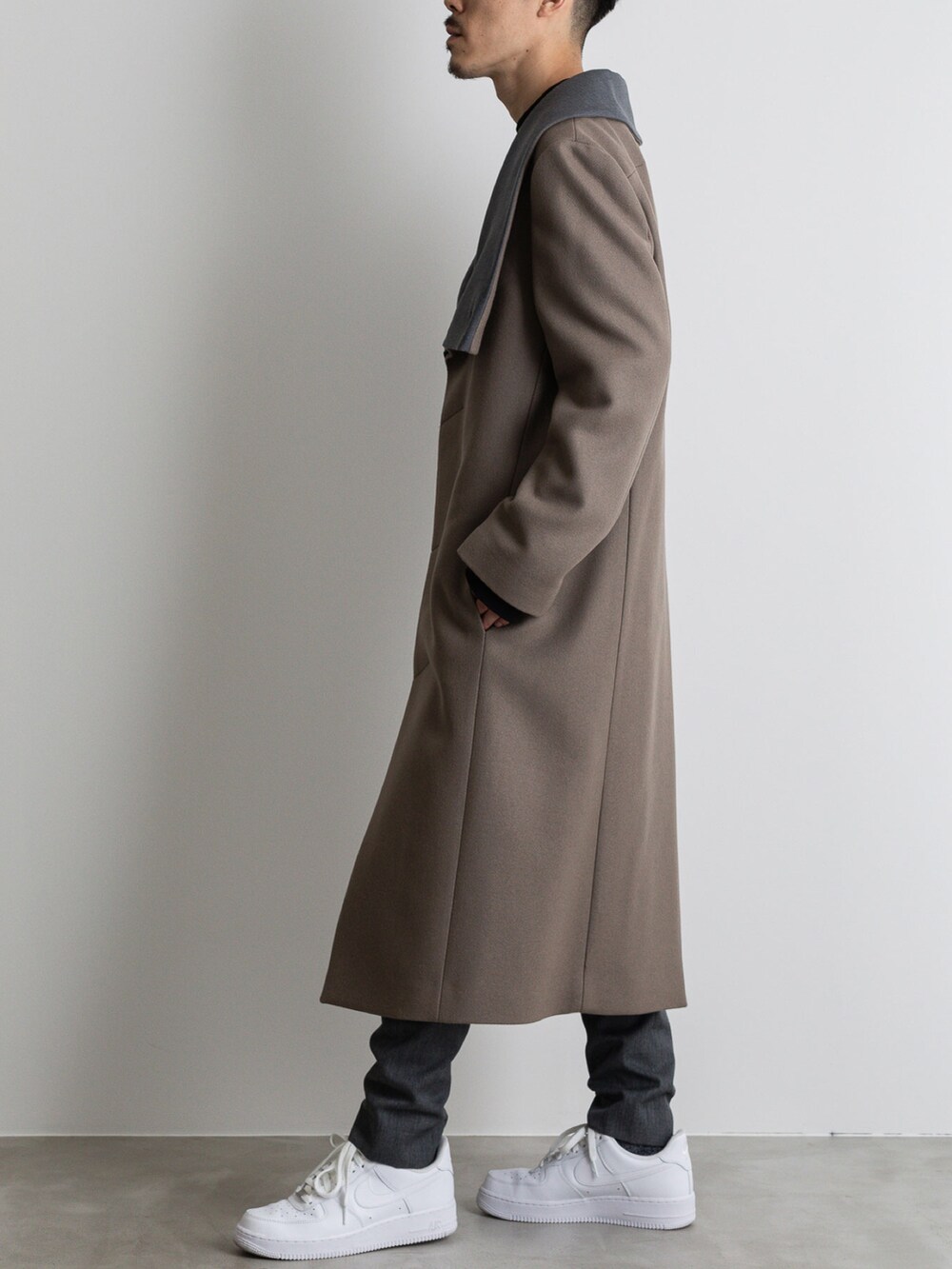 グレー系のその他パンツ、ベージュ系のチェスターコートを着用したメンズの冬コーディネートの5枚目の写真