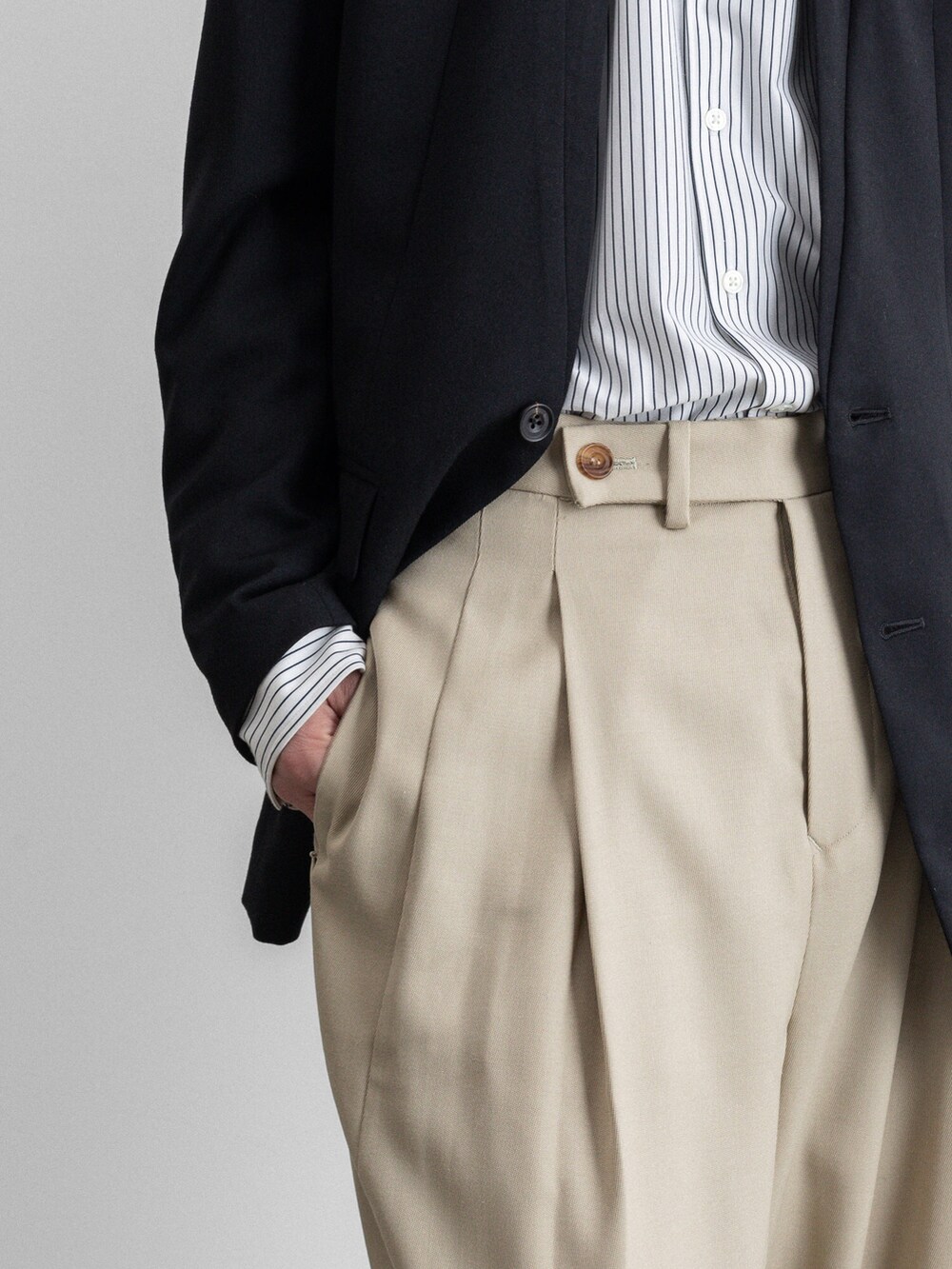 ブラック系のテーラードジャケット、ベージュ系のその他パンツを着用したメンズの冬コーディネートの4枚目の写真