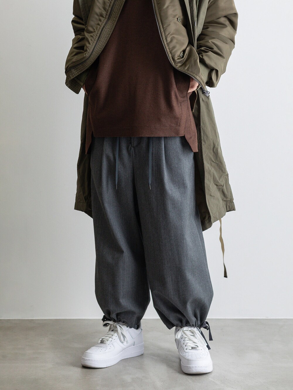 グリーン系のモッズコート、ブラウン系のTシャツ/カットソー、グレー系のその他パンツを着用したメンズの冬コーディネートの5枚目の写真