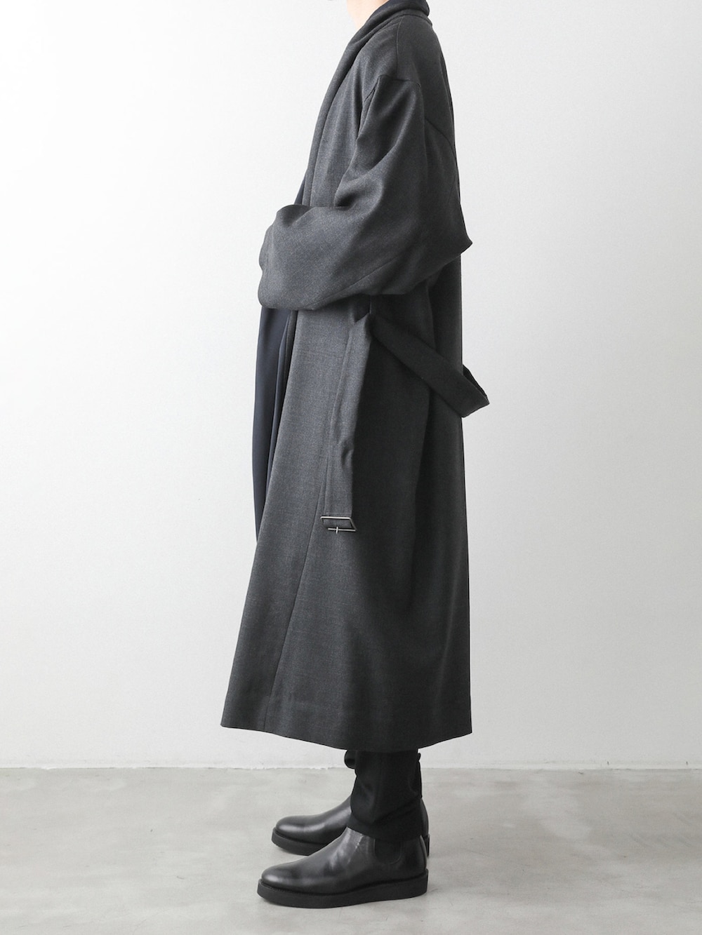 グレー系のノーカラーコート、ブラック系のその他パンツを着用したメンズの秋コーディネートの3枚目の写真