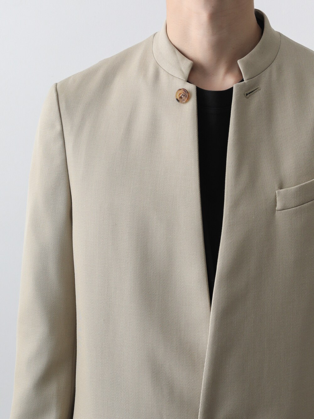 ベージュ系のテーラードジャケット、ブラック系のその他パンツを着用したメンズの秋コーディネートの2枚目の写真