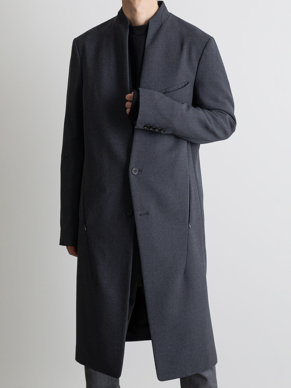 グレー系のその他パンツ、グレー系のノーカラーコートを着用したメンズの冬コーディネートの2枚目の写真