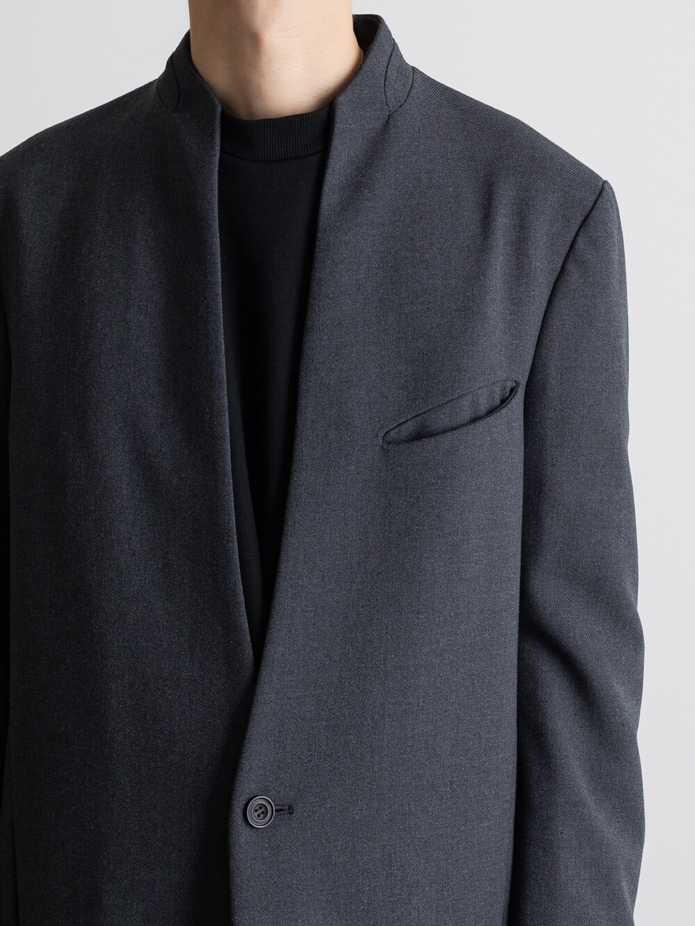 グレー系のその他パンツ、グレー系のノーカラーコートを着用したメンズの冬コーディネートの3枚目の写真