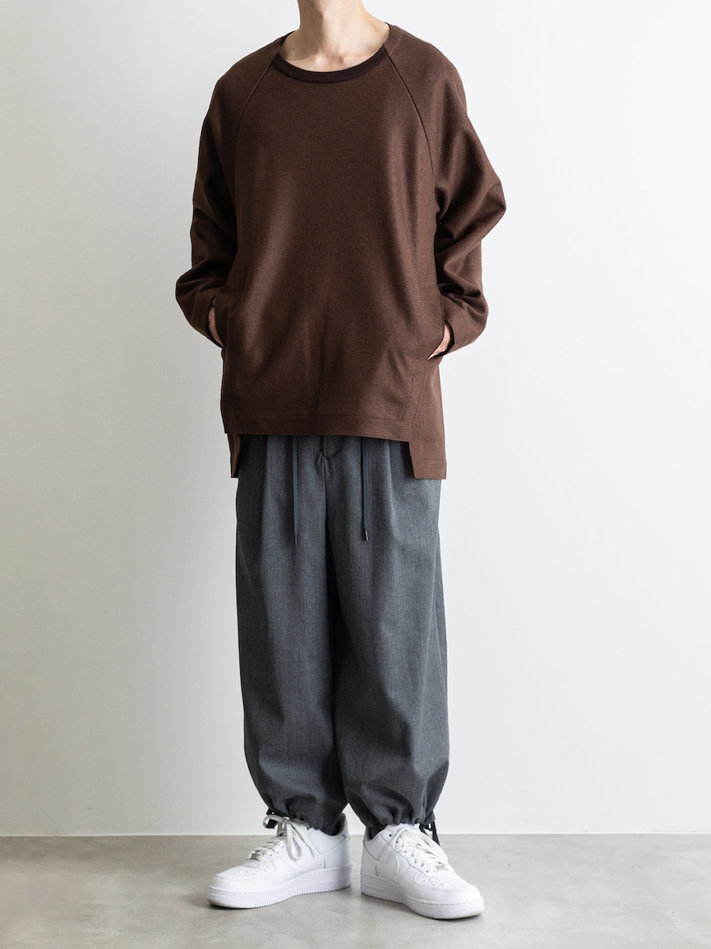 グリーン系のモッズコート、ブラウン系のTシャツ/カットソー、グレー系のその他パンツを着用したメンズの冬コーディネートの3枚目の写真