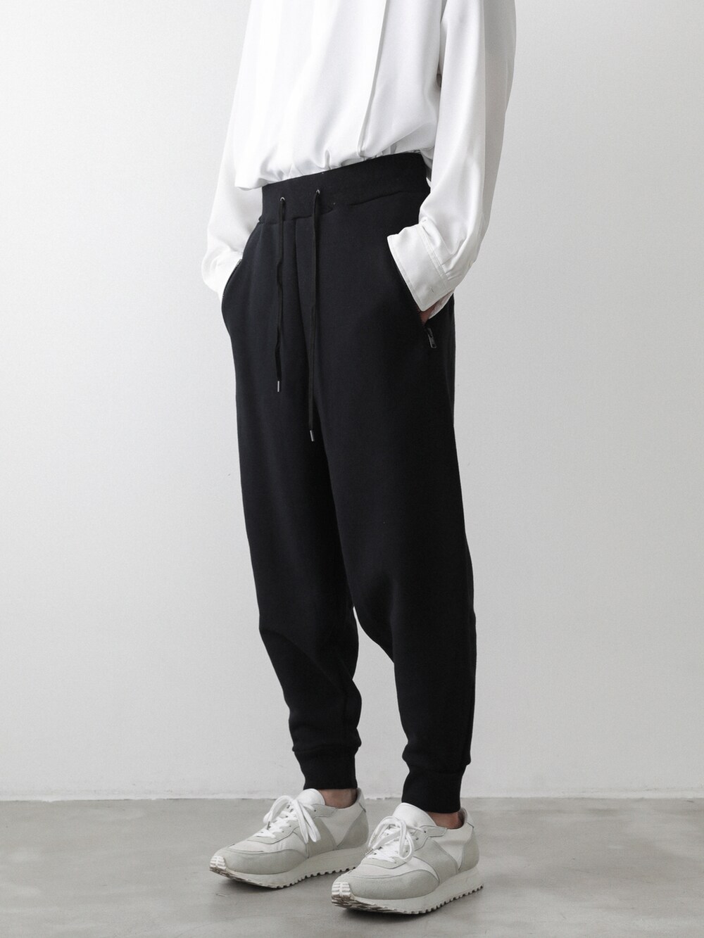 ブラック系のトレンチコート、ホワイト系のシャツ/ブラウス、ブラック系のTシャツ/カットソーを着用したメンズの秋コーディネートの5枚目の写真