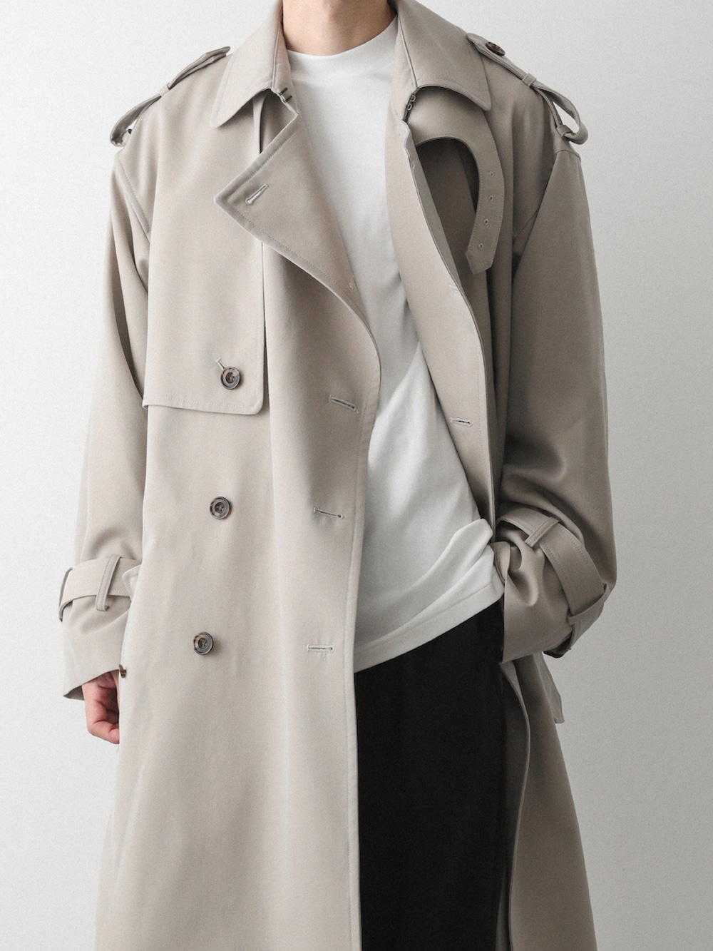 ベージュ系のトレンチコート、ブラック系のその他パンツを着用したメンズの秋コーディネートの4枚目の写真