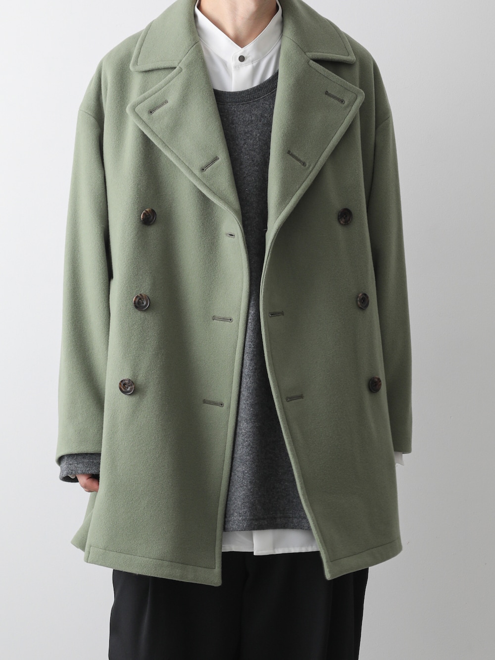 グリーン系のピーコート、グレー系のTシャツ/カットソー、ホワイト系のシャツ/ブラウスを着用したメンズの秋コーディネートの3枚目の写真