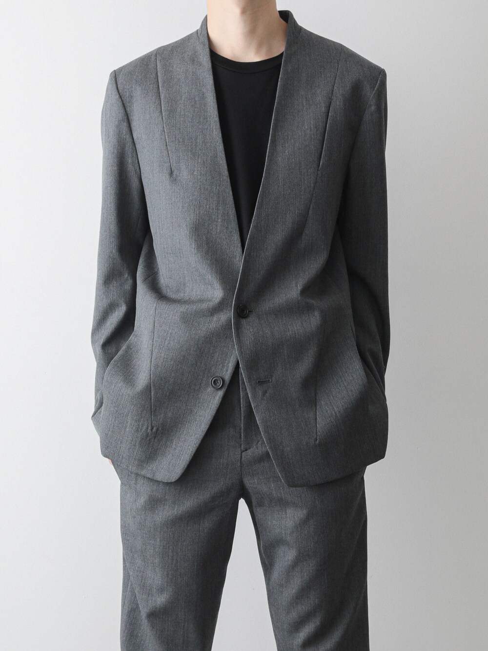 グレー系のノーカラージャケット、グレー系のスラックス、ブラック系のTシャツ/カットソーを着用したメンズの夏コーディネートの2枚目の写真